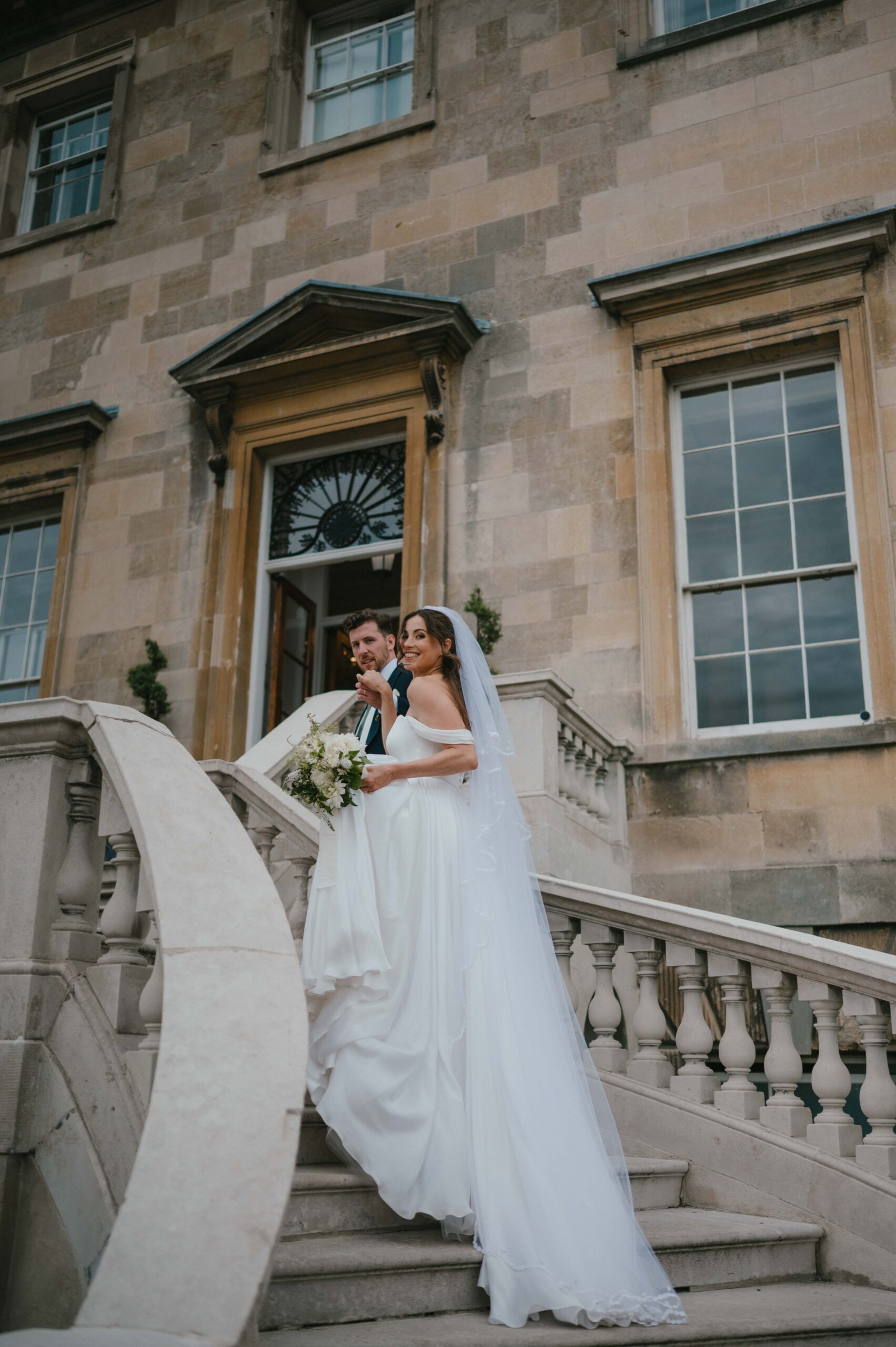 Charlie and Martin strike a confident, editorial pose on the sweeping staircase at Botleys Mansion in Surrey.