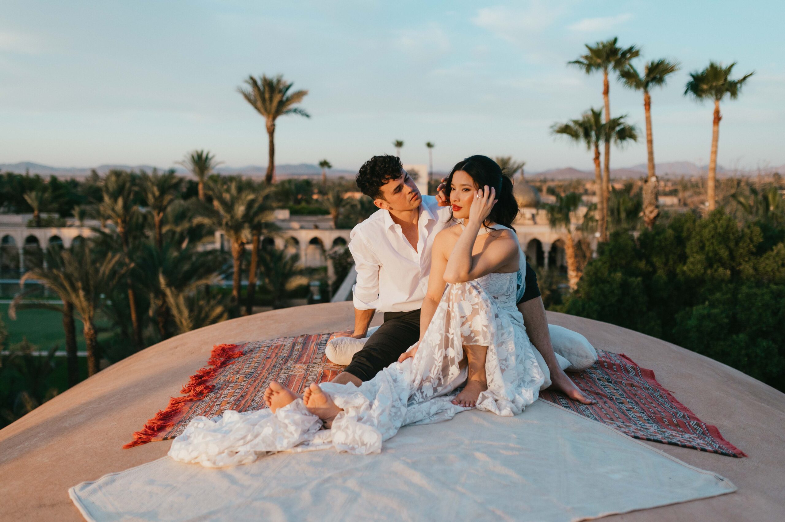On the dome rooftop of the Palais, a couple sits together, enjoying the breathtaking views of Marrakech. Their quiet moment, beautifully captured by wedding photographer Sarah Hurja, radiates peace and affection.