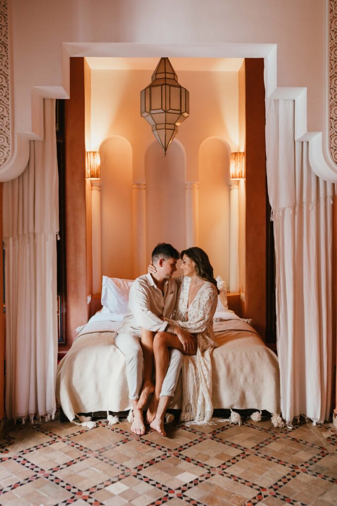 Paul and Lisa sitting on the masterbed in their suite at Riad Yasmine.