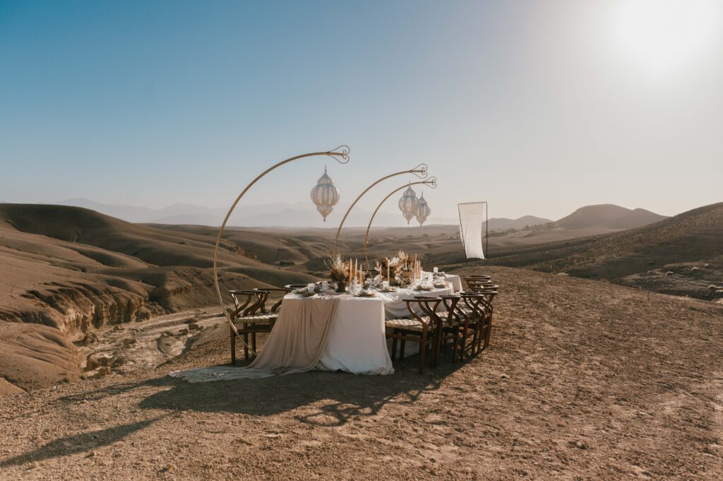 The elegant “wave table” set for the wedding breakfast, adorned with locally sourced Moroccan décor and dry florals, blending perfectly with the desert surroundings.