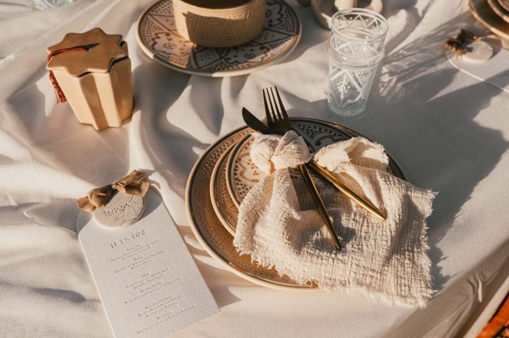 A close-up of the intricate details of the "wave table," with Moroccan lanterns, textured fabrics, and beautiful dry florals, adding a modern touch to the Marrakech desert elopement.