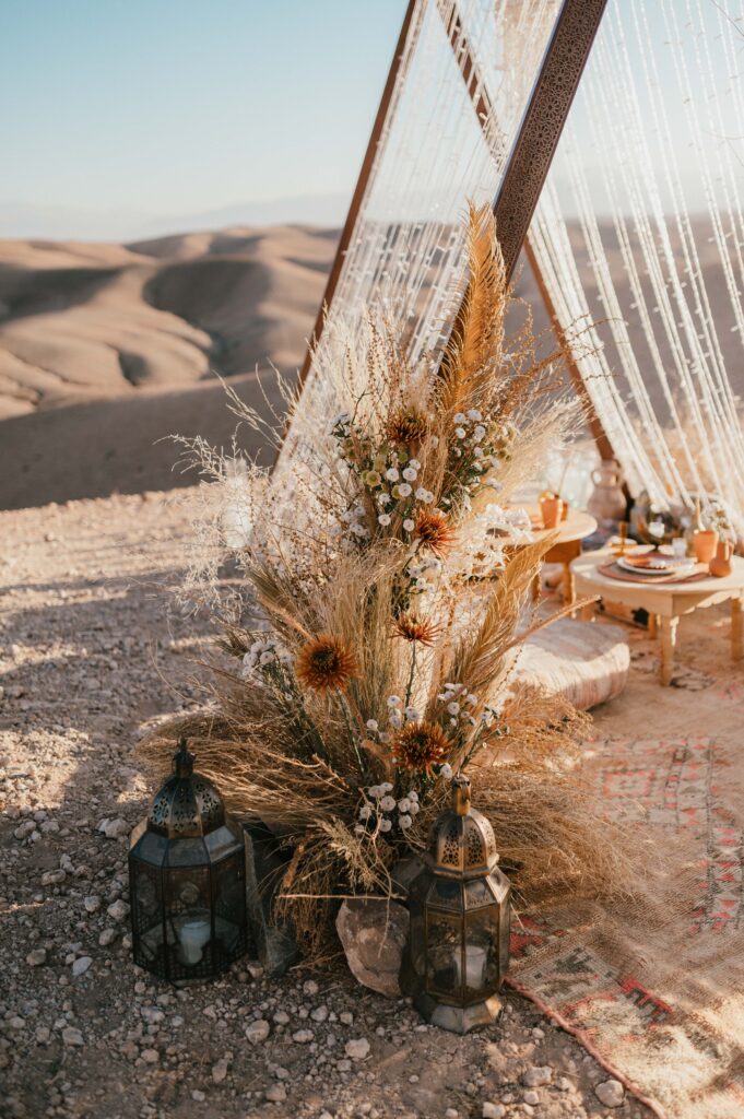 A detailed shot of the locally sourced Moroccan décor, including colorful pillows, ornate lamps, and Berber rugs, enhancing the Marrakech desert elopement atmosphere, designed by La Perle Events Marrakech Wedding Planner and florals by The Bloom Room Marrakech.