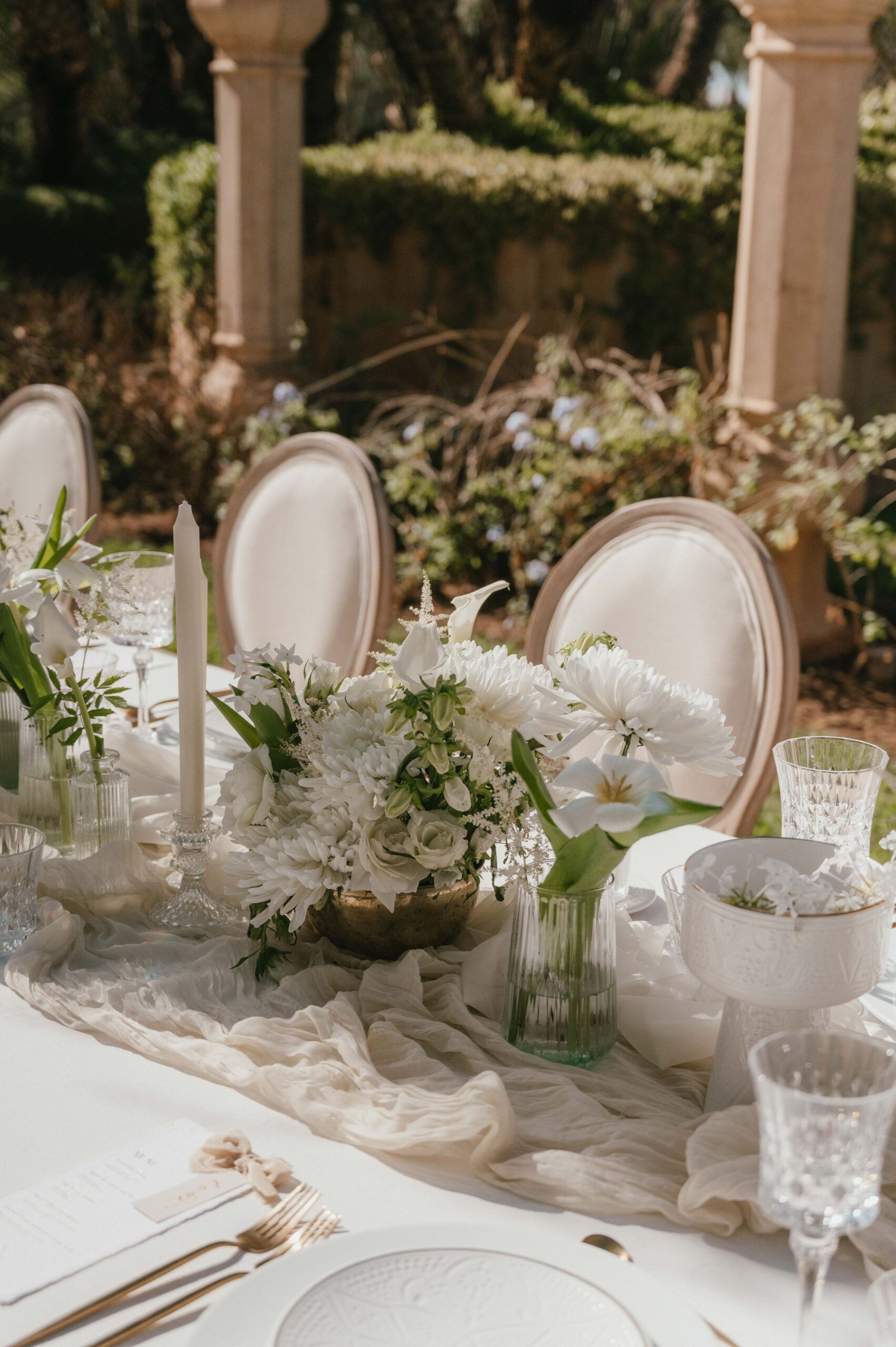 An elegantly styled wedding reception table at Palais Namaskar, Marrakech, adorned with fine tableware, fresh florals, and a warm, inviting ambiance that perfectly complements the venue’s opulent Moroccan design.